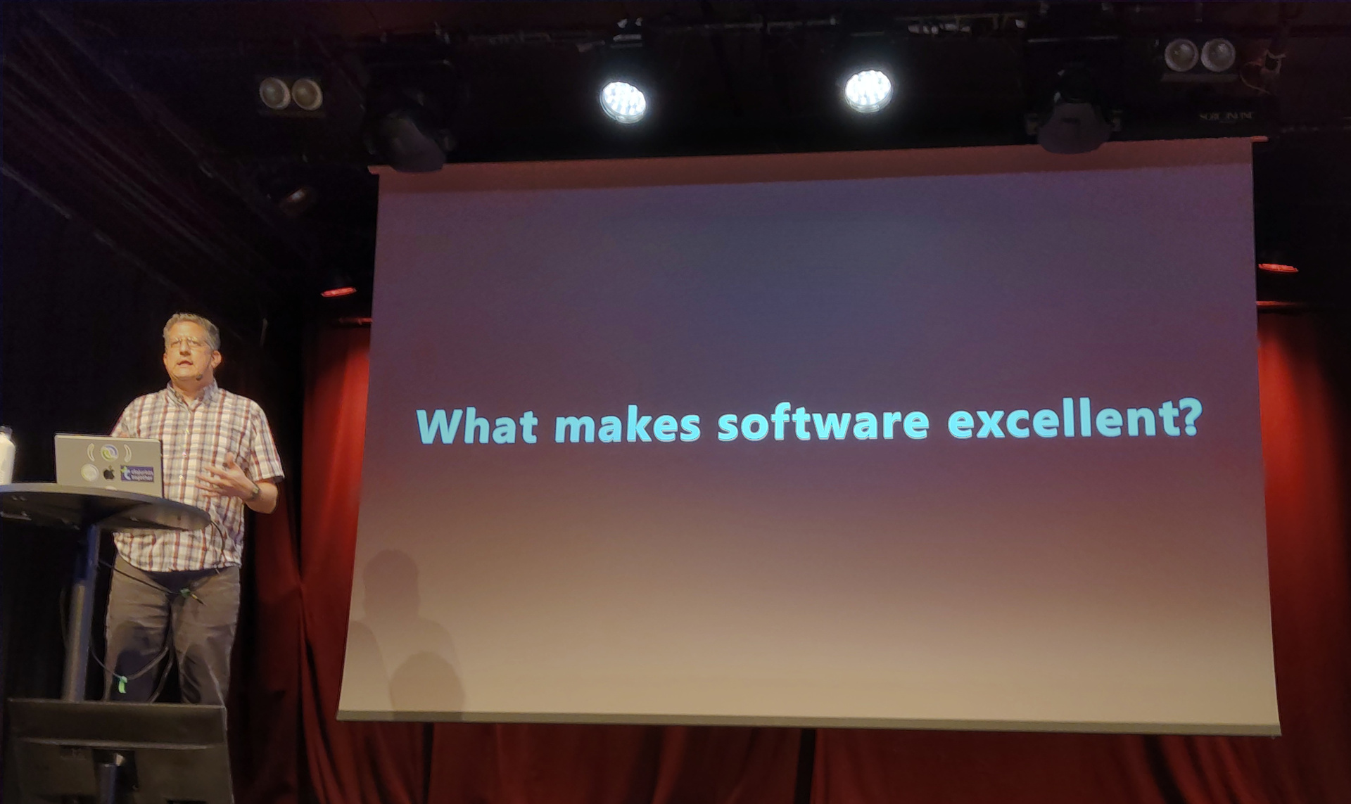 It's written in Clojure! By a human! Christoph presents a slide labelled "What makes software excellent?"